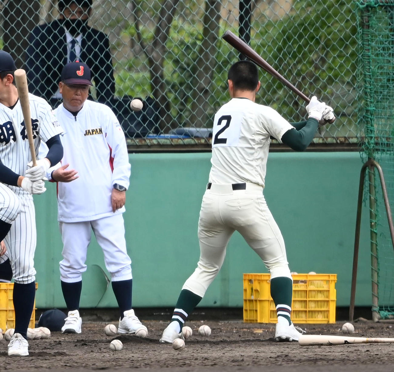 打撃練習で報徳学園・堀（右）にトスを上げる馬淵監督（撮影・前岡正明）