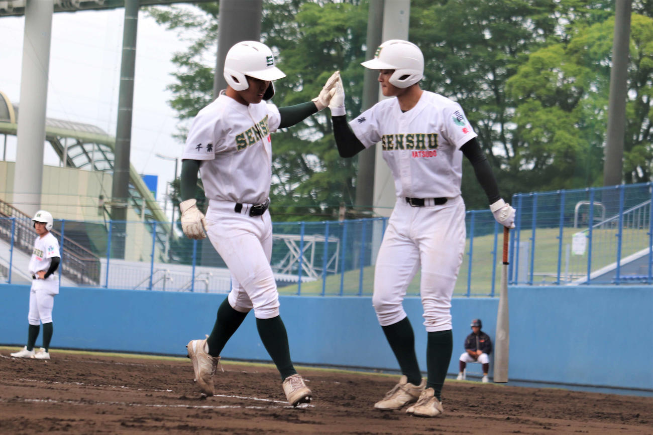 市立松戸－専大松戸　6回、2死から左越えソロ本塁打を放ち、チームメートとハイタッチをする専大松戸・吉田（撮影・保坂淑子）