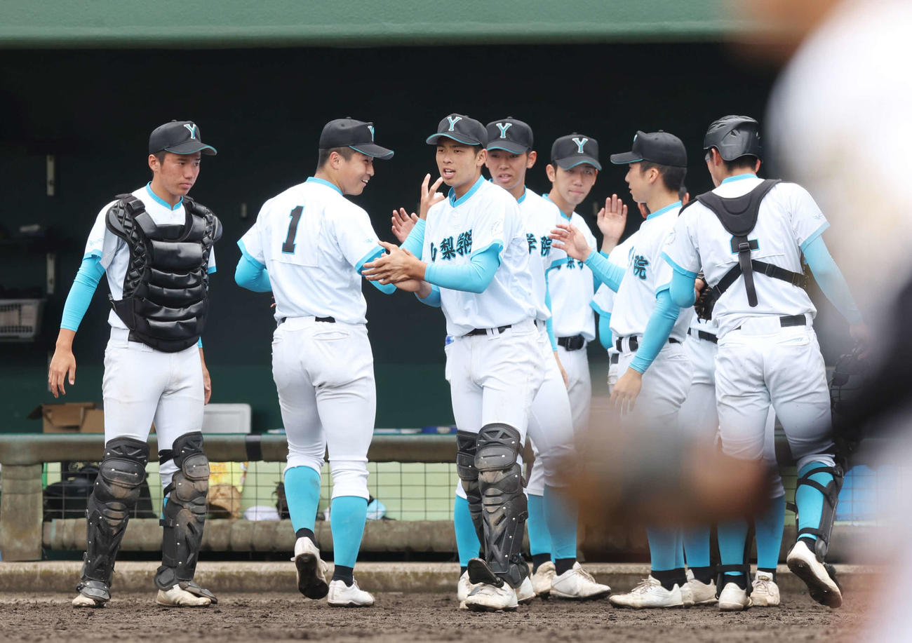 4回表を無失点に抑え、笑顔でベンチに帰る山梨学院先発の林（左から2人目）（撮影・宮地輝）