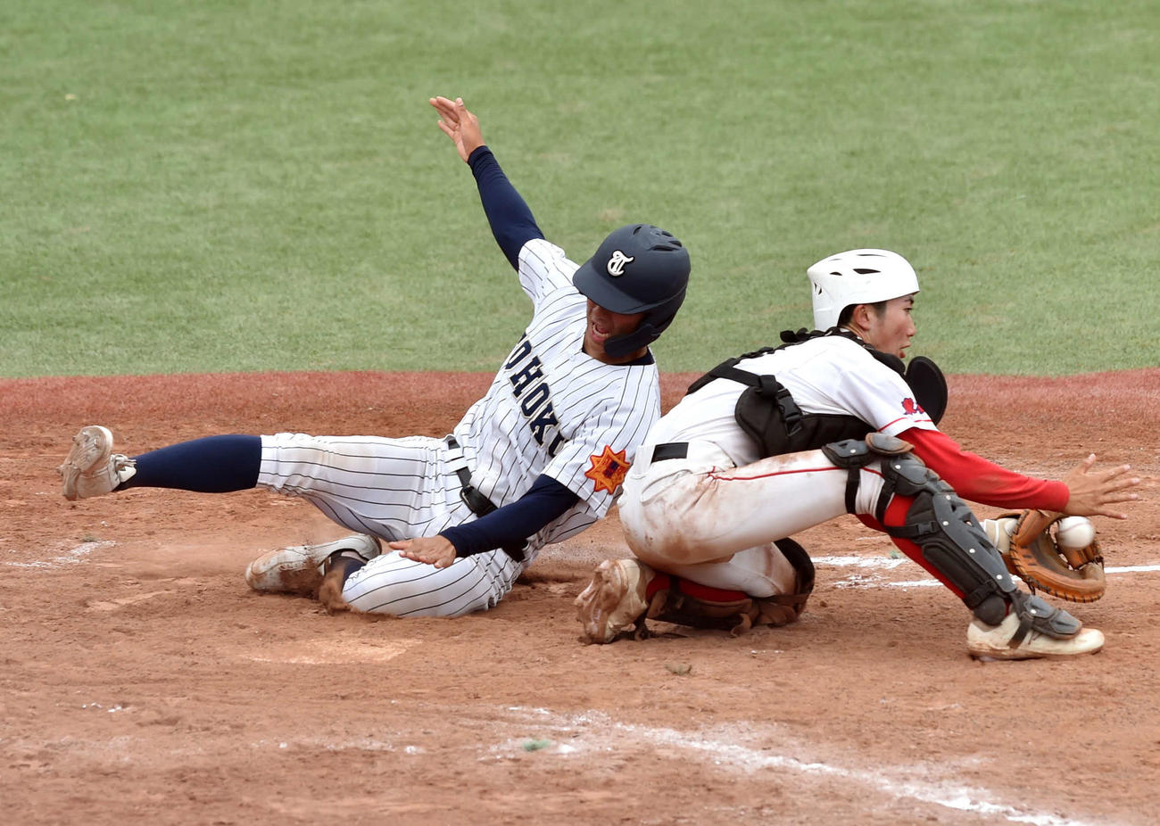 日本ウェルネス宮城対東北　5回裏東北1死二、三塁、佐藤響の中飛で本塁に滑り込む日隈（左）（撮影・相沢孔志）