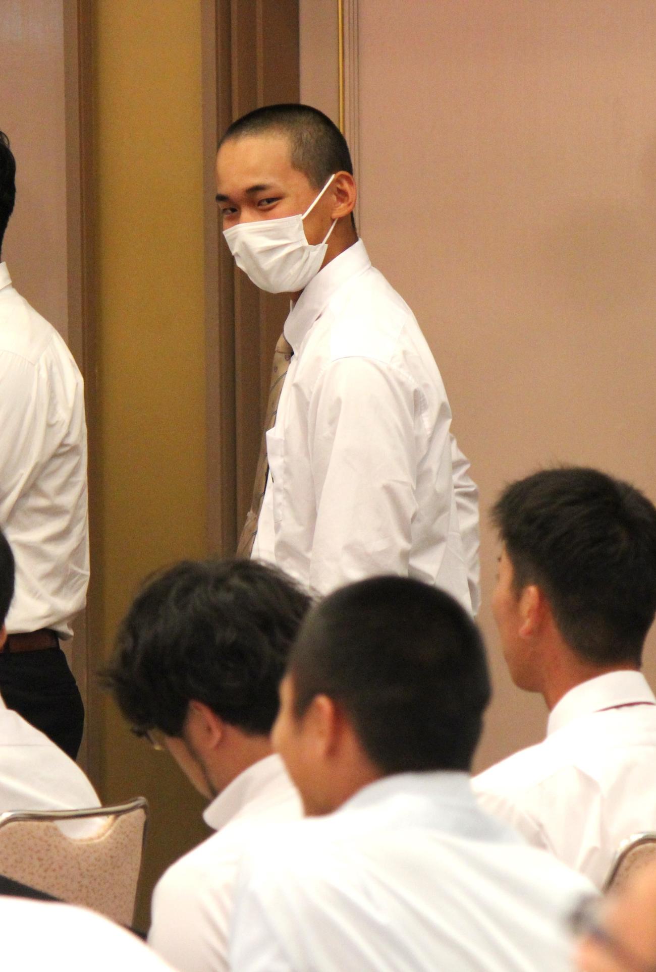 抽選会で履正社・森沢主将（手前）を見つけてアイコンタクトする大阪桐蔭・前田主将（撮影・柏原誠）