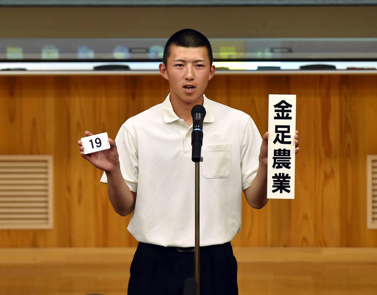 金足農のボードを掲げる吉田主将