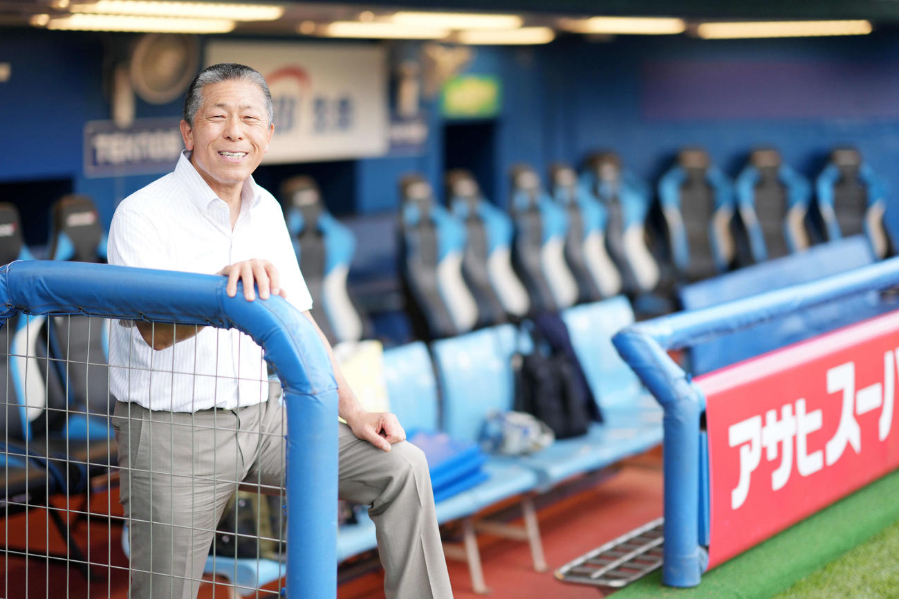 監督時代、試合中にいつも立っていた場所で笑顔を見せる小倉全由氏（撮影・横山健太）