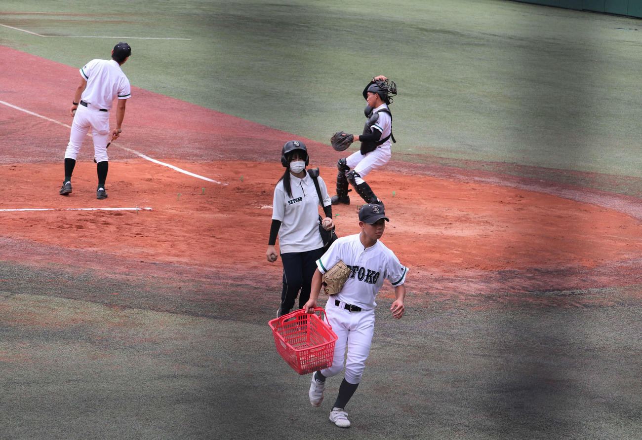 瀬戸工科対鳴海　練習に欠かせない“選手と同じヘルメット”をかぶってノックをサポートする瀬戸工科の女子マネージャー、川上美夢（みゆ、3年）さん（撮影・中島麗）