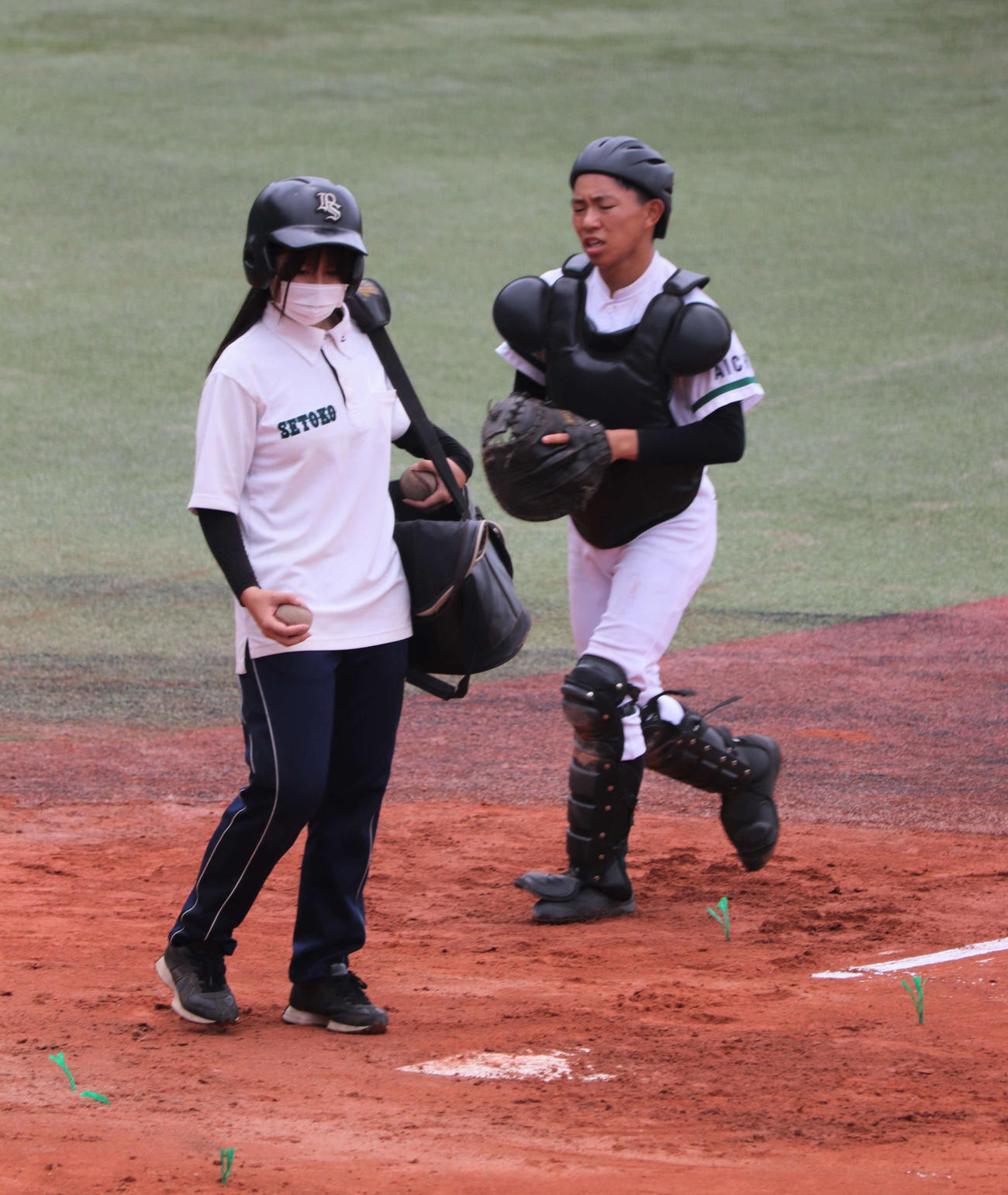 瀬戸工科対鳴海　練習に欠かせない“選手と同じヘルメット”をかぶってノックをサポートする瀬戸工科の女子マネージャー、川上美夢（みゆ、3年）さん（撮影・中島麗）