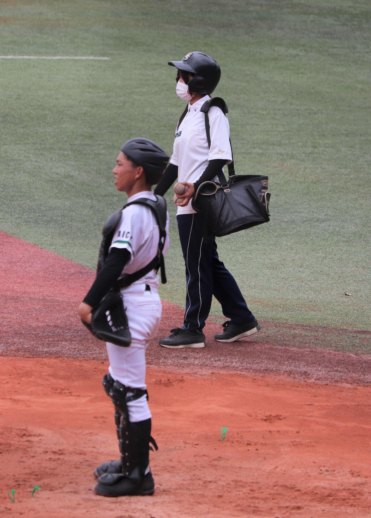 瀬戸工科対鳴海　練習に欠かせない“選手と同じヘルメット”をかぶってノックをサポートする瀬戸工科の女子マネージャー、川上美夢（みゆ、3年）さん（撮影・中島麗）