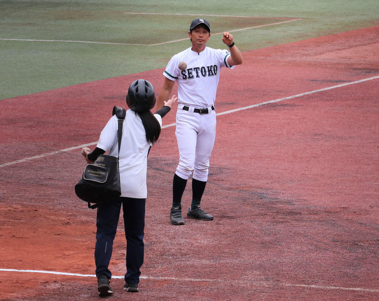瀬戸工科対鳴海　練習に欠かせない“選手と同じヘルメット”をかぶってノッカーにボールを渡す瀬戸工科の女子マネージャー、川上美夢（みゆ、3年）さん（撮影・中島麗）