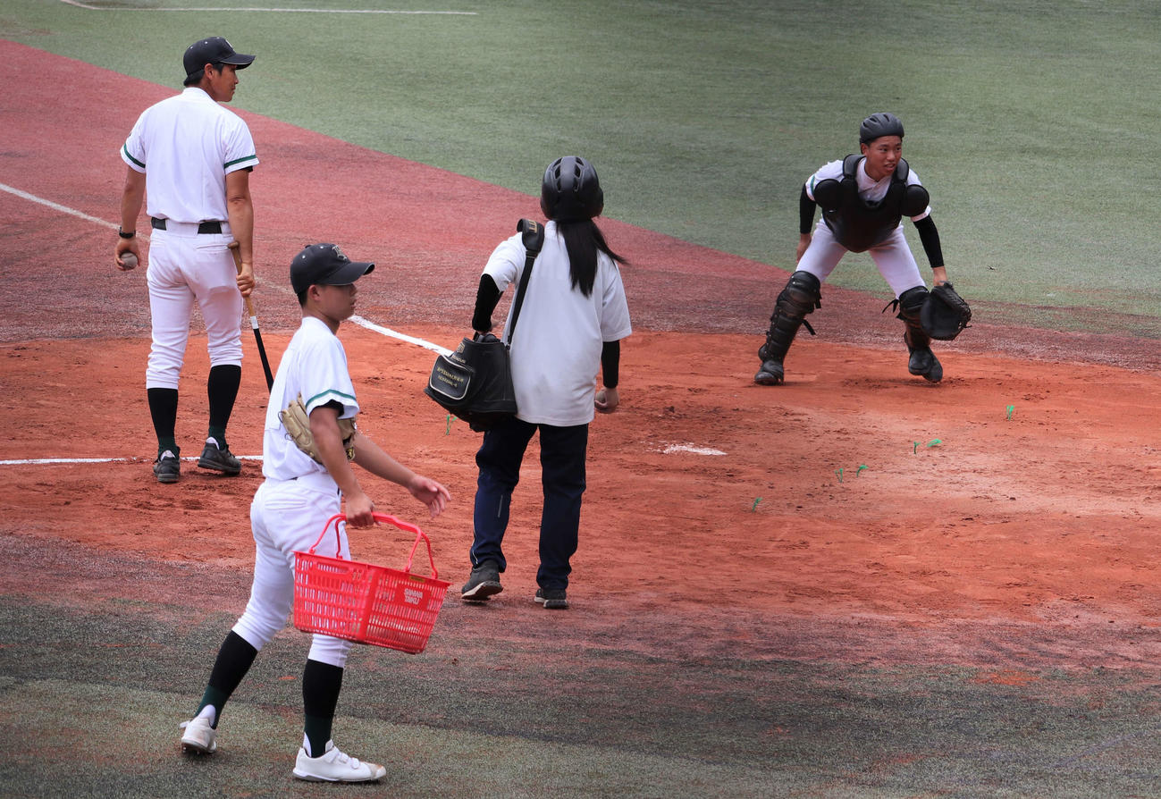 瀬戸工科対鳴海　練習に欠かせない“選手と同じヘルメット”をかぶってノックをサポートする瀬戸工科の女子マネージャー、川上美夢（みゆ、3年）さん（撮影・中島麗）