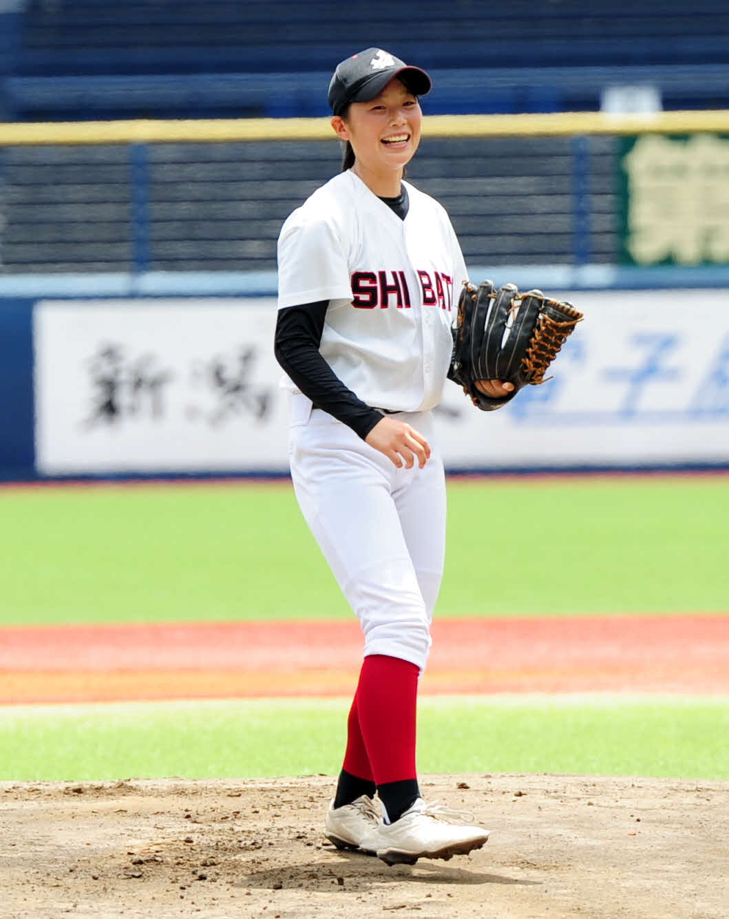 初の女子部員として始球式を務め、マウンド上で笑顔の新発田・渡辺