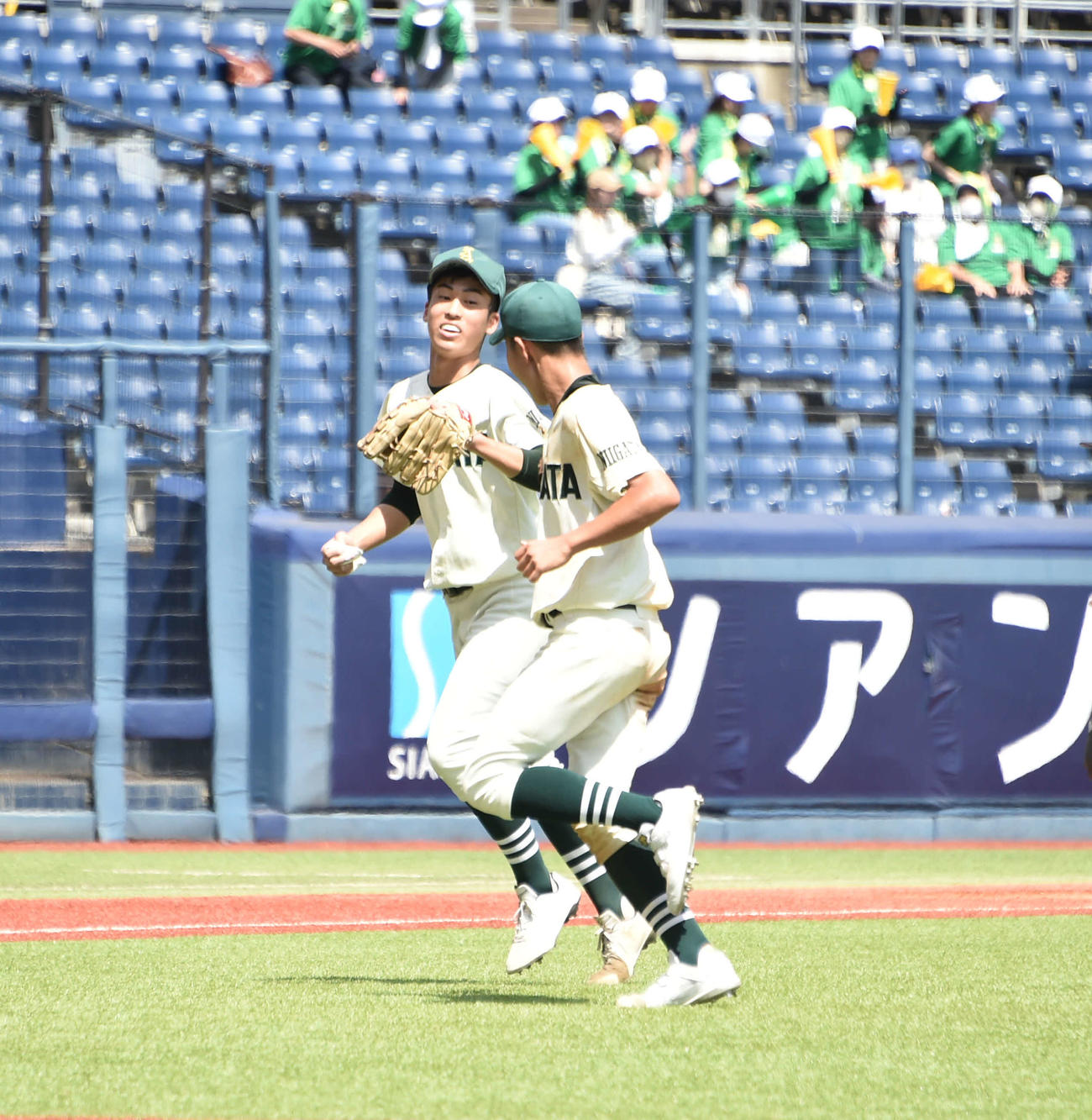 新発田農・遠山（左）は最後の打者を遊ゴロに打ち取り、吉村遊撃手とタッチ