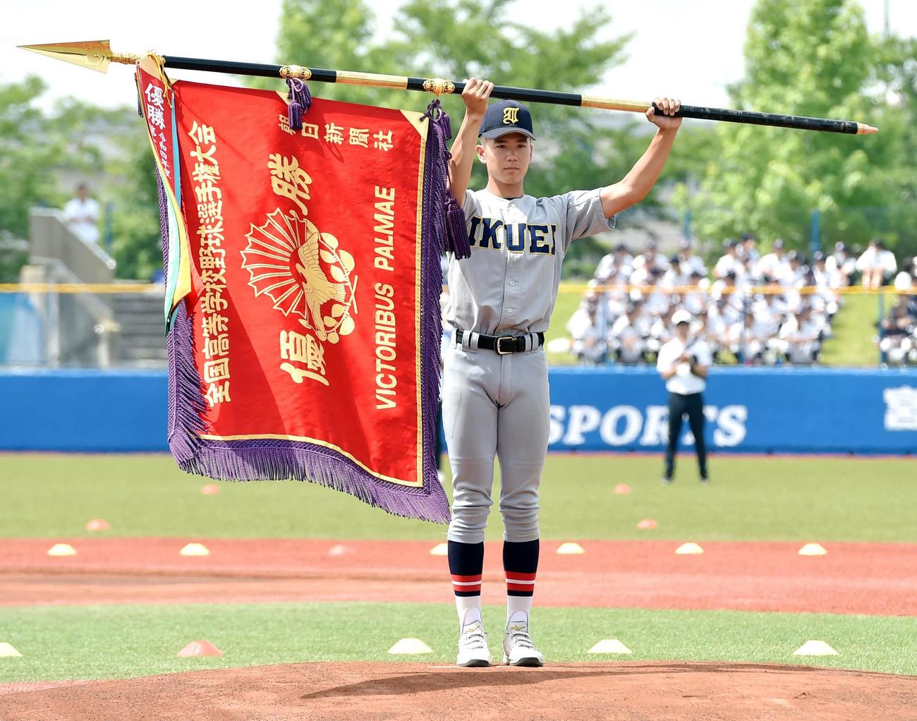 開会式前に深紅の優勝旗をマウンドで掲げる仙台育英・山田主将（撮影・相沢孔志）