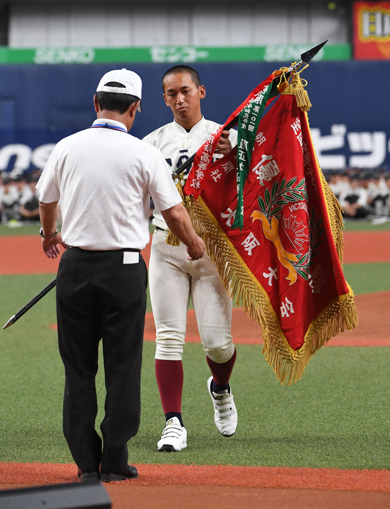大阪大会の開会式で優勝旗を返還する前年度優勝の大阪桐蔭・前田主将（撮影・前岡正明）