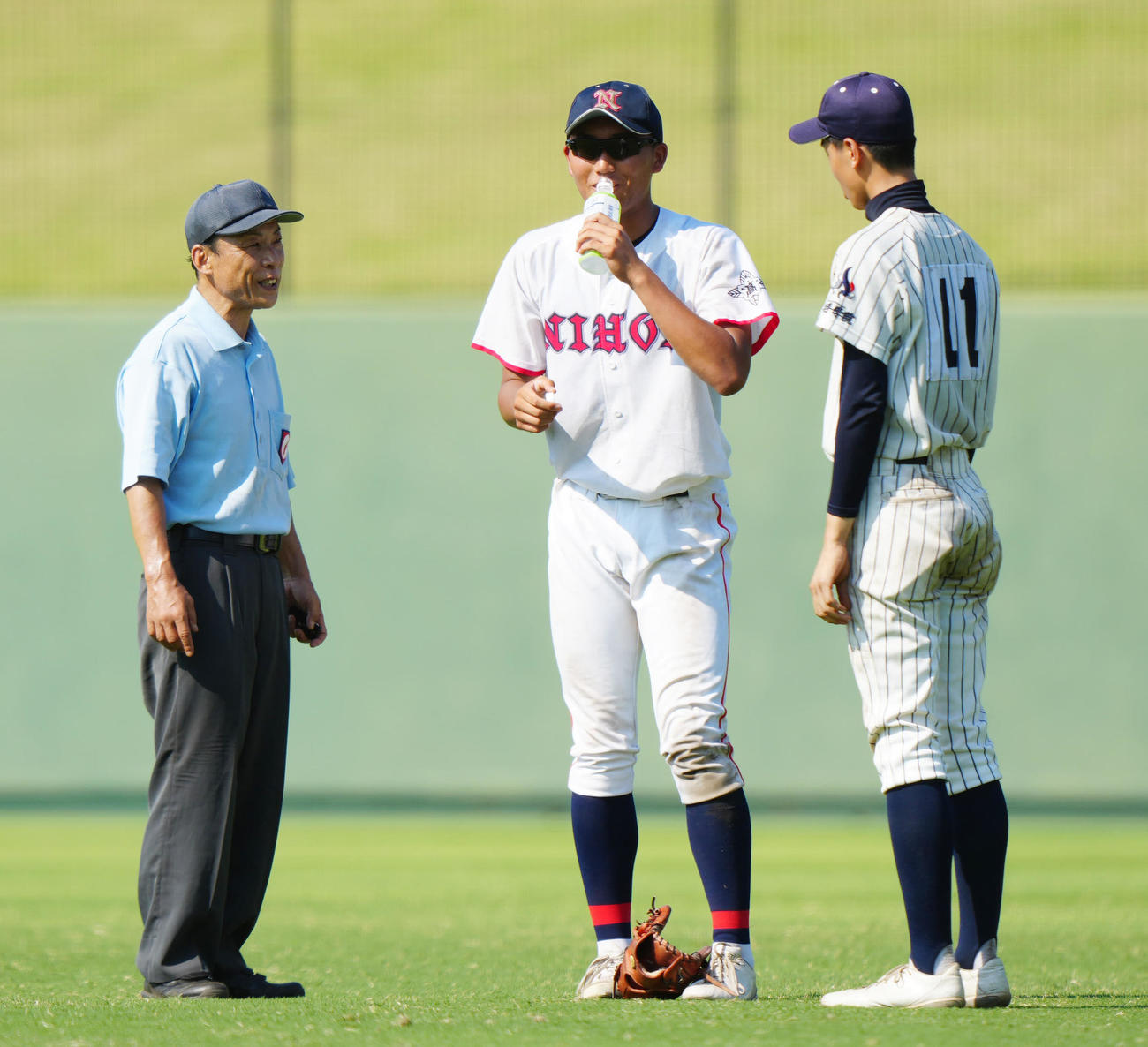 日大高対山手学院　7回裏途中、山手学院・小松（右）から経口補水液を受け取る日大高・大竹（撮影・江口和貴）