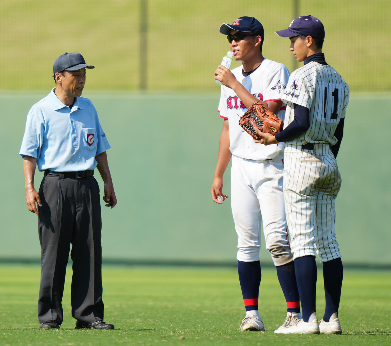 日大高対山手学院　7回裏途中、山手学院・小松（右）から経口補水液を受け取る日大高・大竹（撮影・江口和貴）
