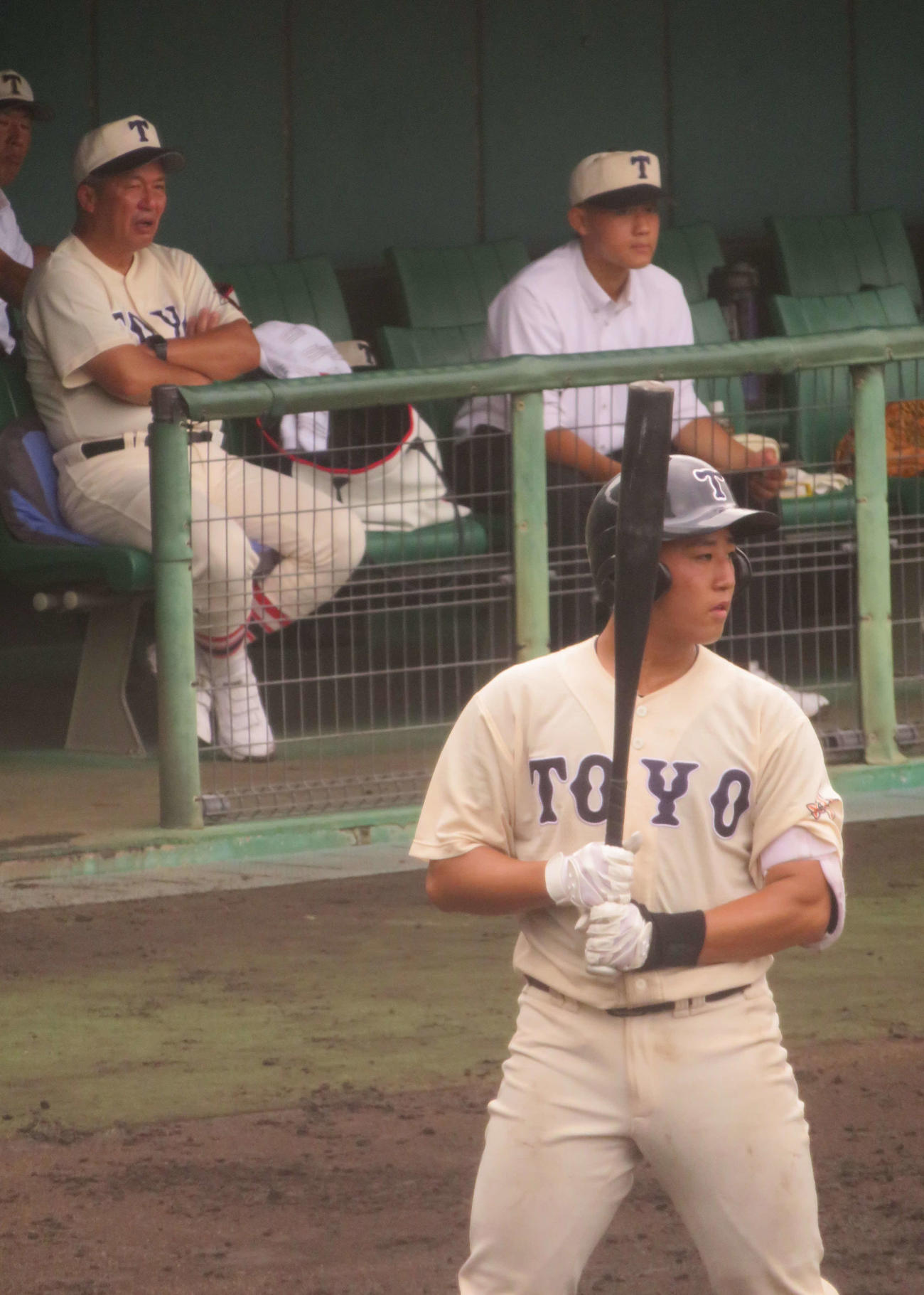 網干対東洋大姫路　戦況を見守る東洋大姫路・岡田龍生監督（左奥）。手前は5番の■（■は卉の下に木）原大礼捕手（撮影・磯綾乃）