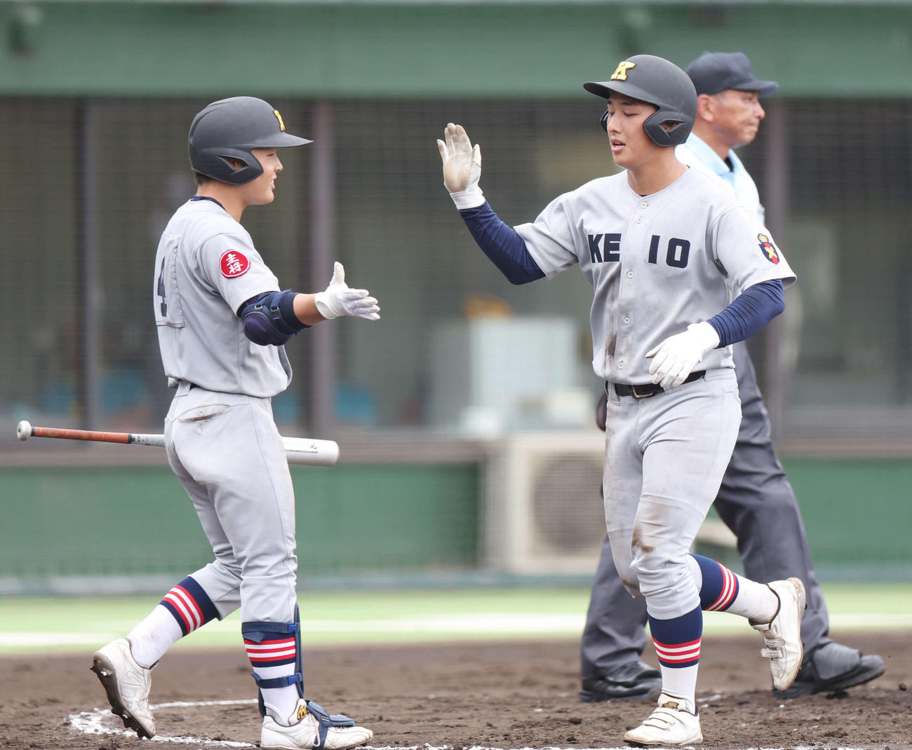津久井浜対慶応　3回裏慶応2死二塁、八木が先制適時二塁打を放ち、生還して大村（左）とタッチする清原（撮影・宮地輝）
