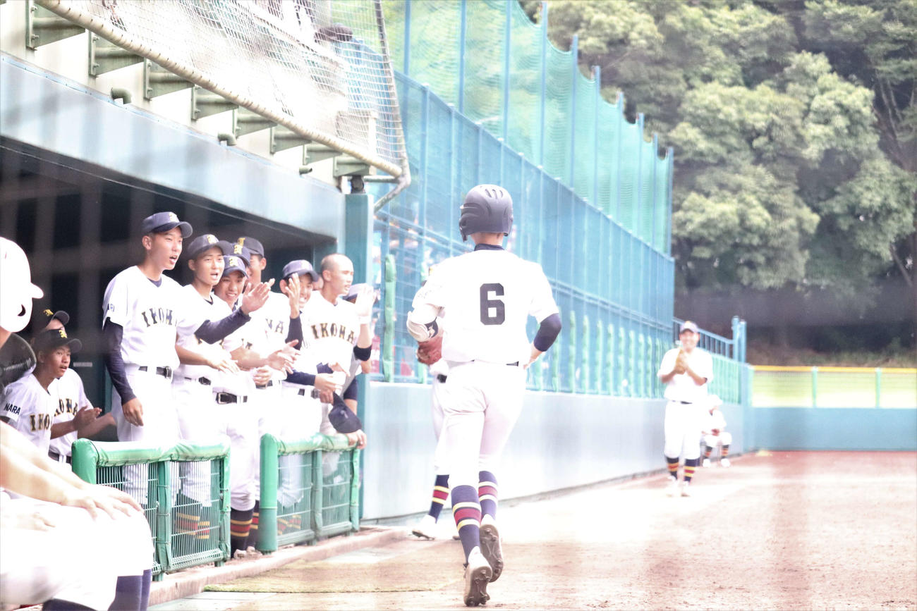 生駒対奈良高専　生駒・3回二死で先制点となる本塁打を放ち、ナインに迎えられる菅田（撮影・松野奈音）