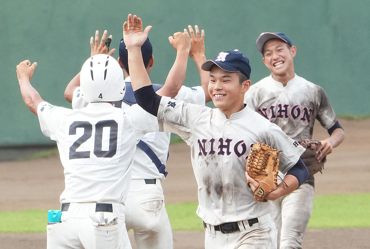 八王子学園八王子に勝利し、笑顔でタッチをする日大鶴ケ丘ナイン（撮影・菅敏）