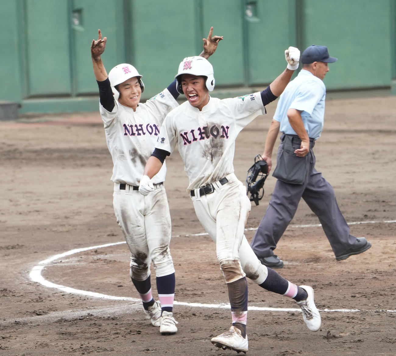 日大鶴ケ丘対八王子学園八王子　2回表日大鶴ケ丘2死二、三塁、杉浦の中2点適時打で二塁から生還し、ガッツポーズを見せる小針（右）（撮影・菅敏）
