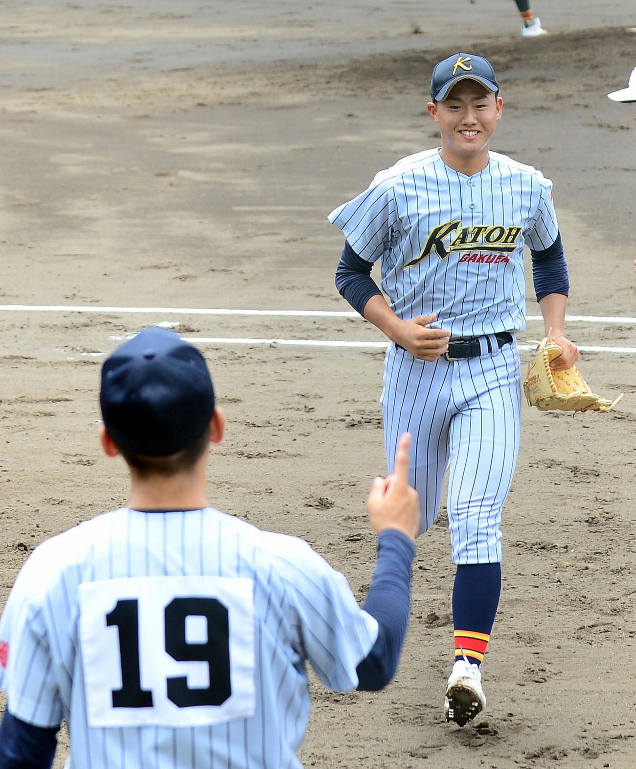 桐陽の攻撃を三者凡退に抑え、笑顔でベンチに戻る加藤学園・吉川
