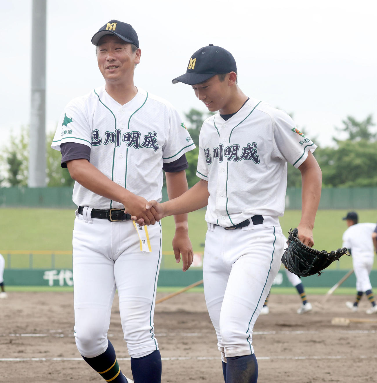 旭川明成対旭川志峯　旭川志峯に勝利し握手をする旭川明成・千葉監督（左）と息子の隆広投手（撮影・佐藤翔太）