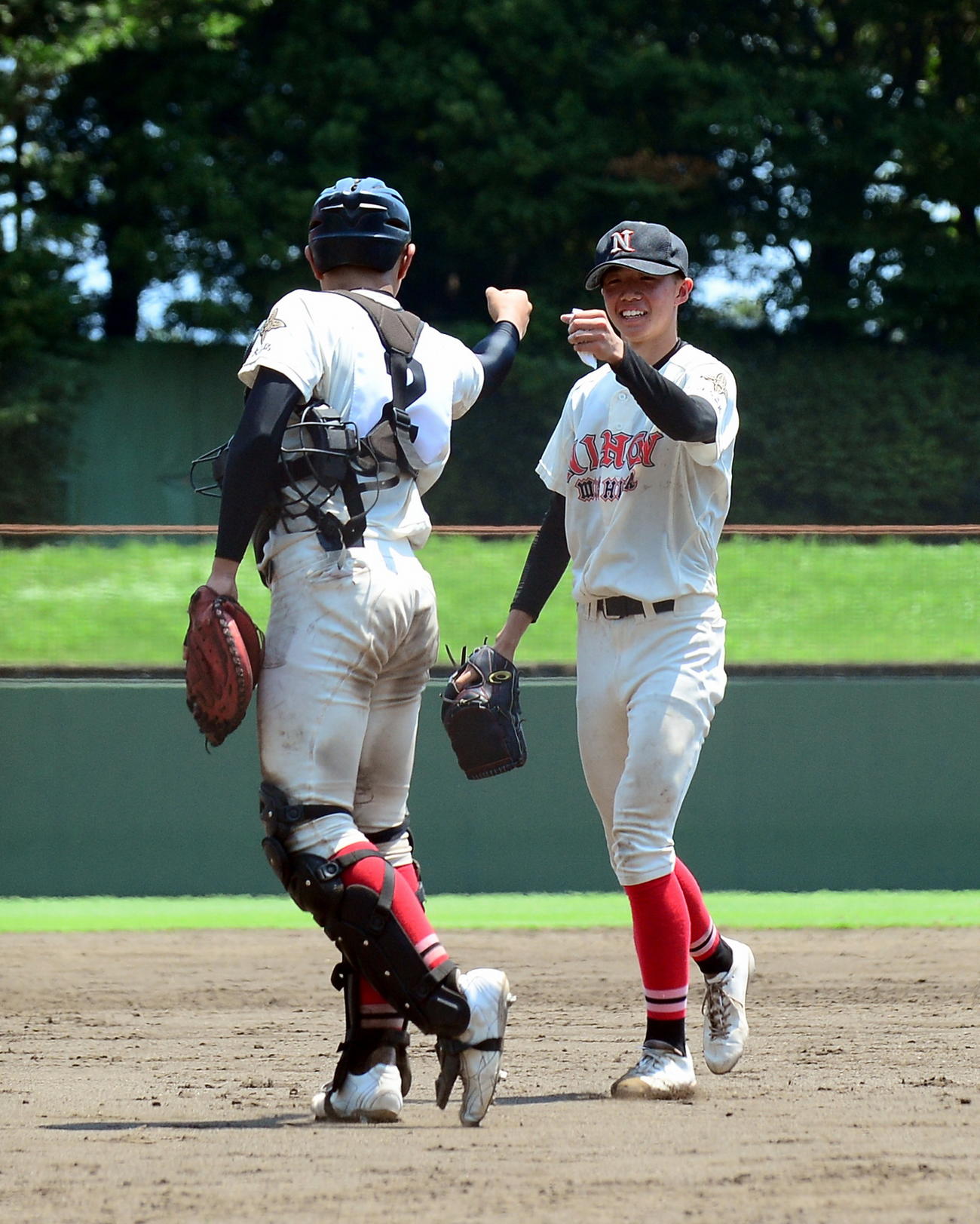 初戦を突破し、野田捕手（手前）とグータッチする日大三島・関野