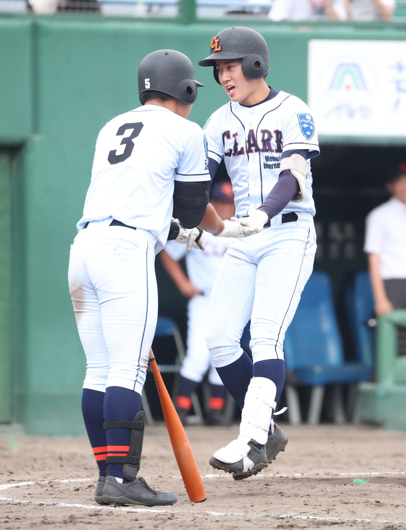 帯広農対クラーク　4回裏クラーク1死、左越え本塁打を放ち中村（左手前）とタッチをする新岡（撮影・佐藤翔太）