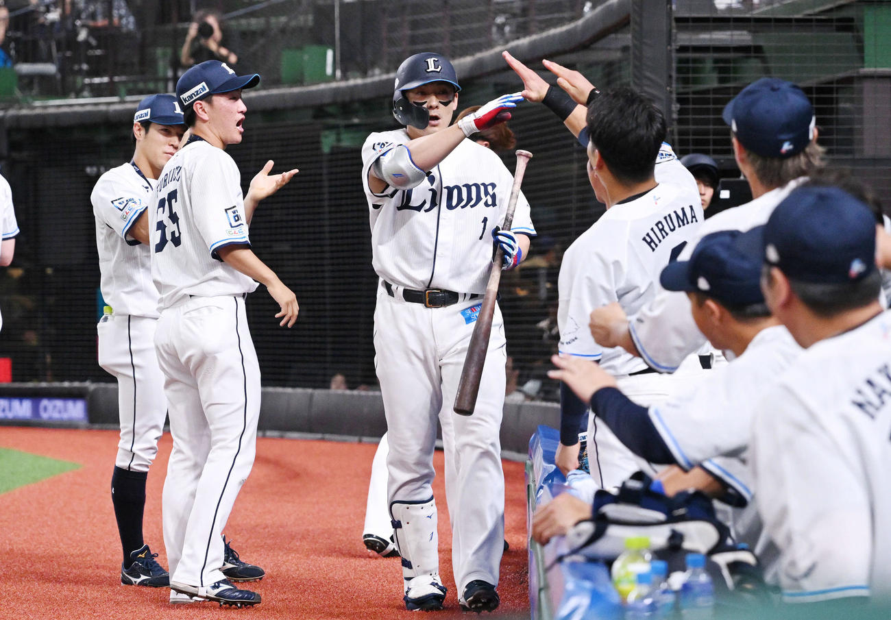 西武対日本ハム　2回裏西武無死、ソロ本塁打を放った栗山（中央）はチームメートとタッチをかわす（撮影・滝沢徹郎）