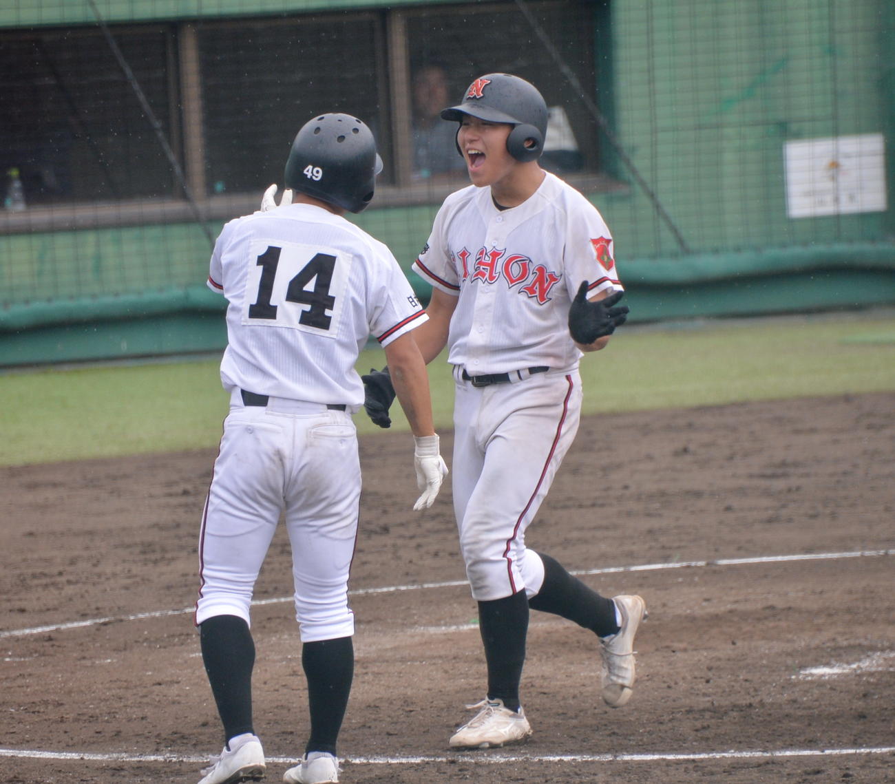 5回、勝ち越しの3点本塁打を放った日大山形・清野（右）は、雄たけびを上げて生還（撮影・濱本神威）