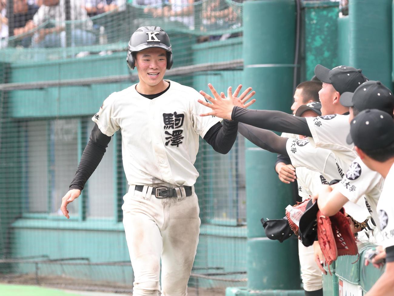 札幌光星対駒大苫小牧　7回裏、生還しナインに出迎えられる駒大苫小牧・瀬野（撮影・黒川智章）