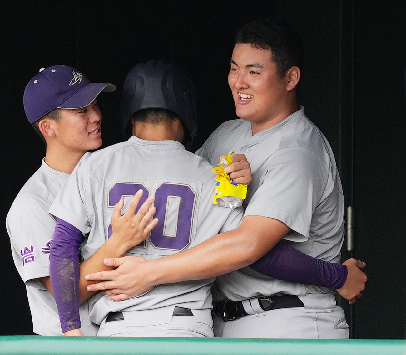 花巻東対水沢商　11回表花巻東1死三塁、小林の適時打で三塁から生還した久慈（中央）をベンチで抱き締める佐々木（撮影・菅敏）