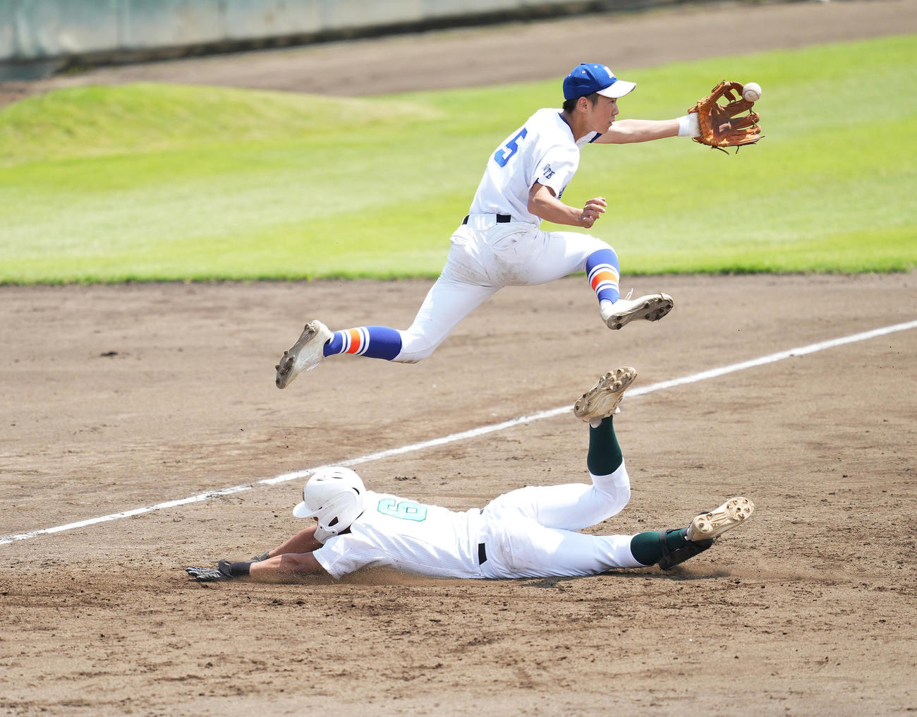 沢第一対専大北上　3回裏専大北上2死一、三塁、右2点適時三塁打を放ち、三塁に滑り込む辻野。上は三塁手鈴木（撮影・菅敏）