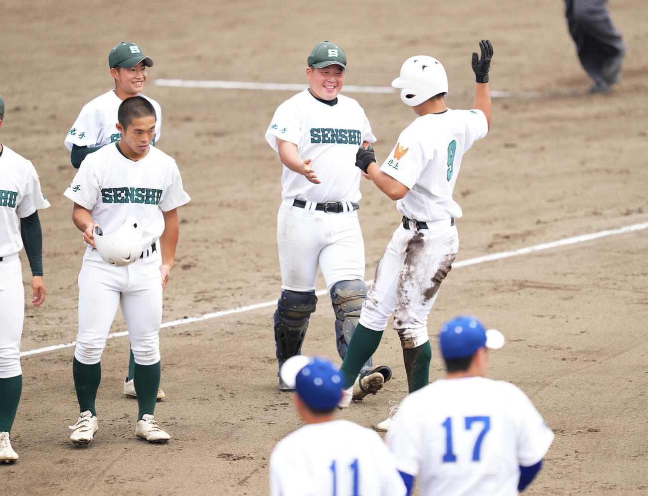 水沢第一対専大北上　5回裏専大北上1死満塁、右中間に2点適時二塁打を放った高橋（右端）は、5回コールドで勝利しナインに迎えられる（撮影・菅敏）