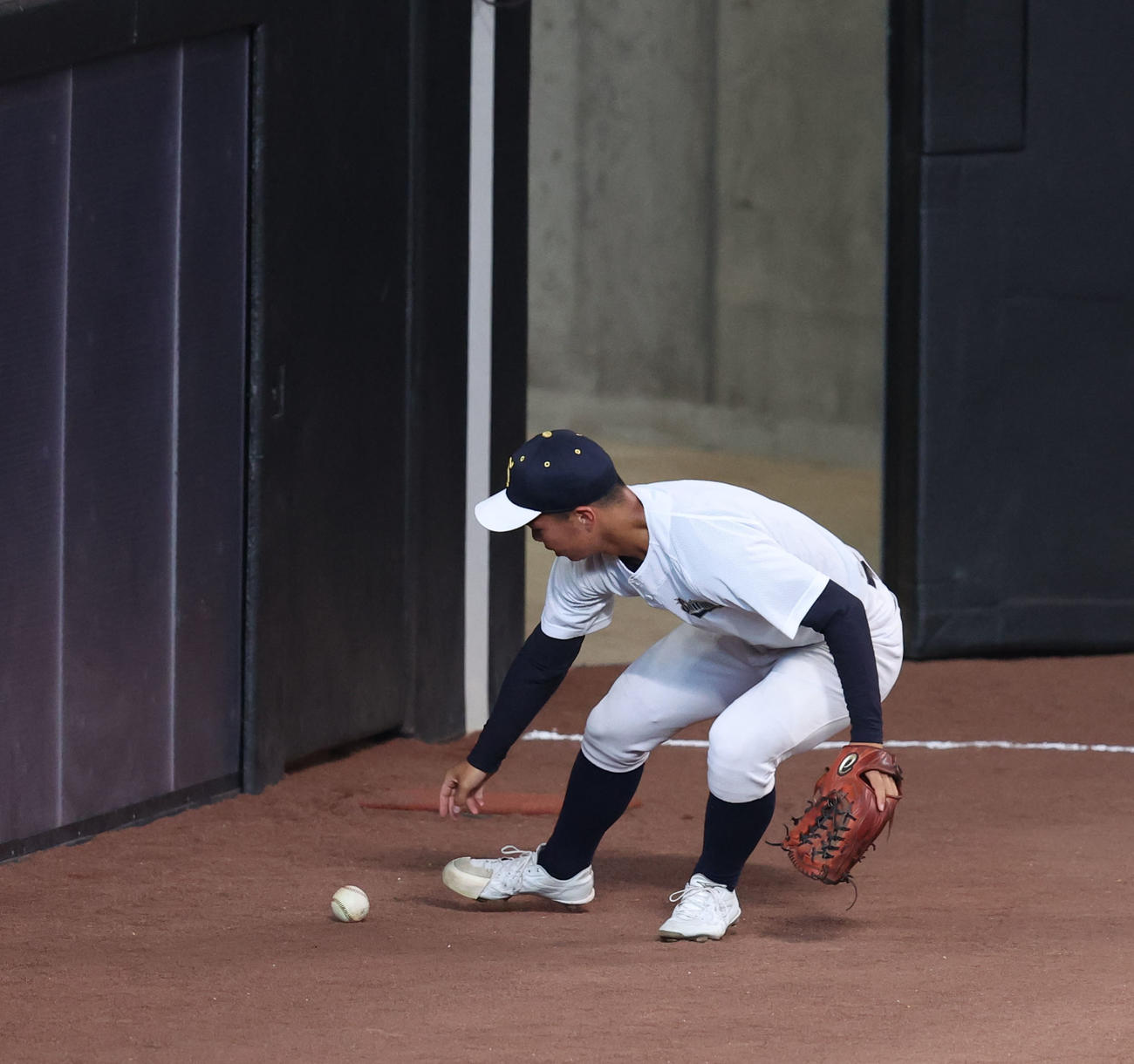 公式練習でフェンスの打球の跳ね返りをチェックする白樺学園の選手（撮影・佐藤翔太）