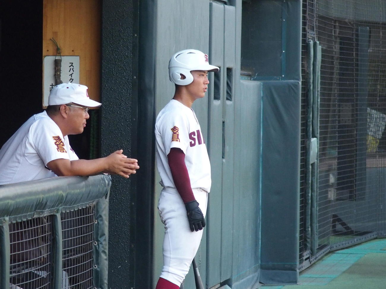 志度対高松中央　ベンチから試合を見る志度・新鞍幸一監督（左）と新鞍護（撮影・永田淳）