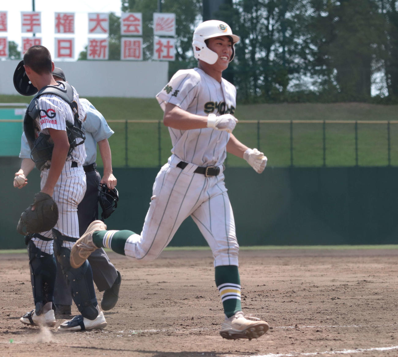 細田学園対昌平で、5回裏に右越え本塁打を放ちホームに生還する昌平・金子内野手（3年）（中央）（撮影・佐瀬百合子）