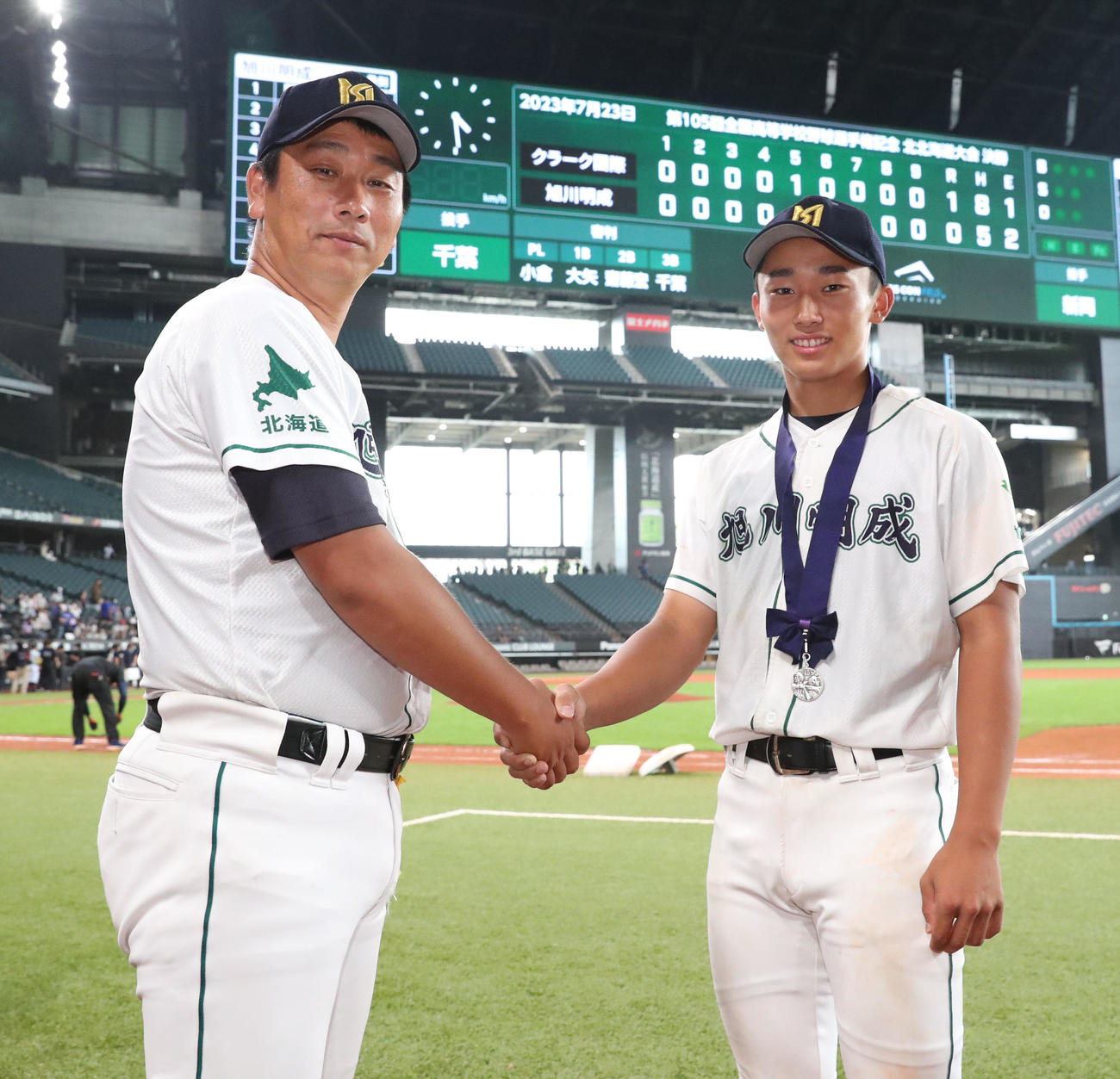 クラーク対旭川明成　記念撮影をする準優勝の旭川明成・千葉広規監督（左）と息子の隆広投手（撮影・佐藤翔太）