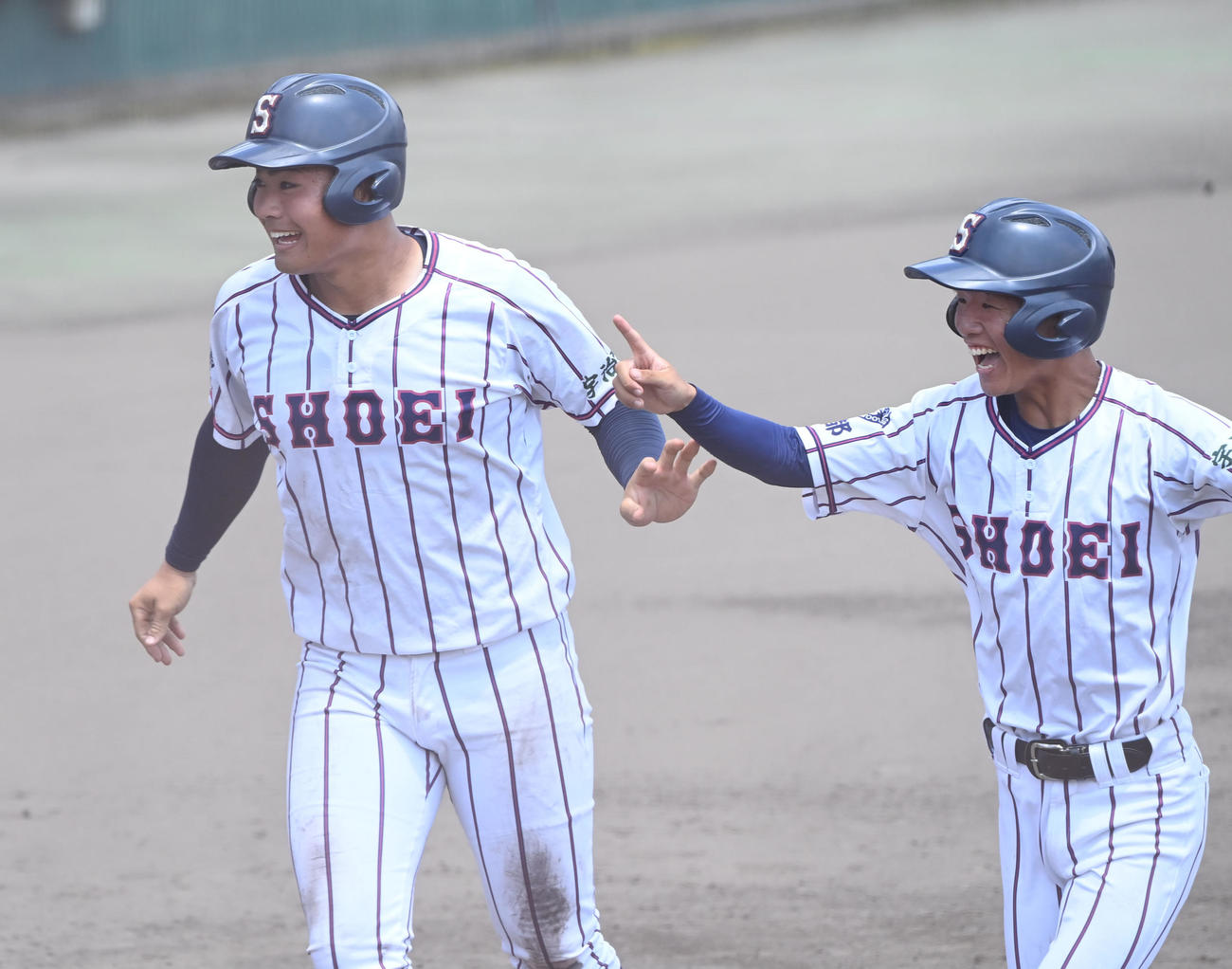 福知山成美対京都翔英　5回裏京都翔英2死満塁、貝阿彌の適時打で生還し笑顔を見せる小笠原（左）（撮影・和賀正仁）