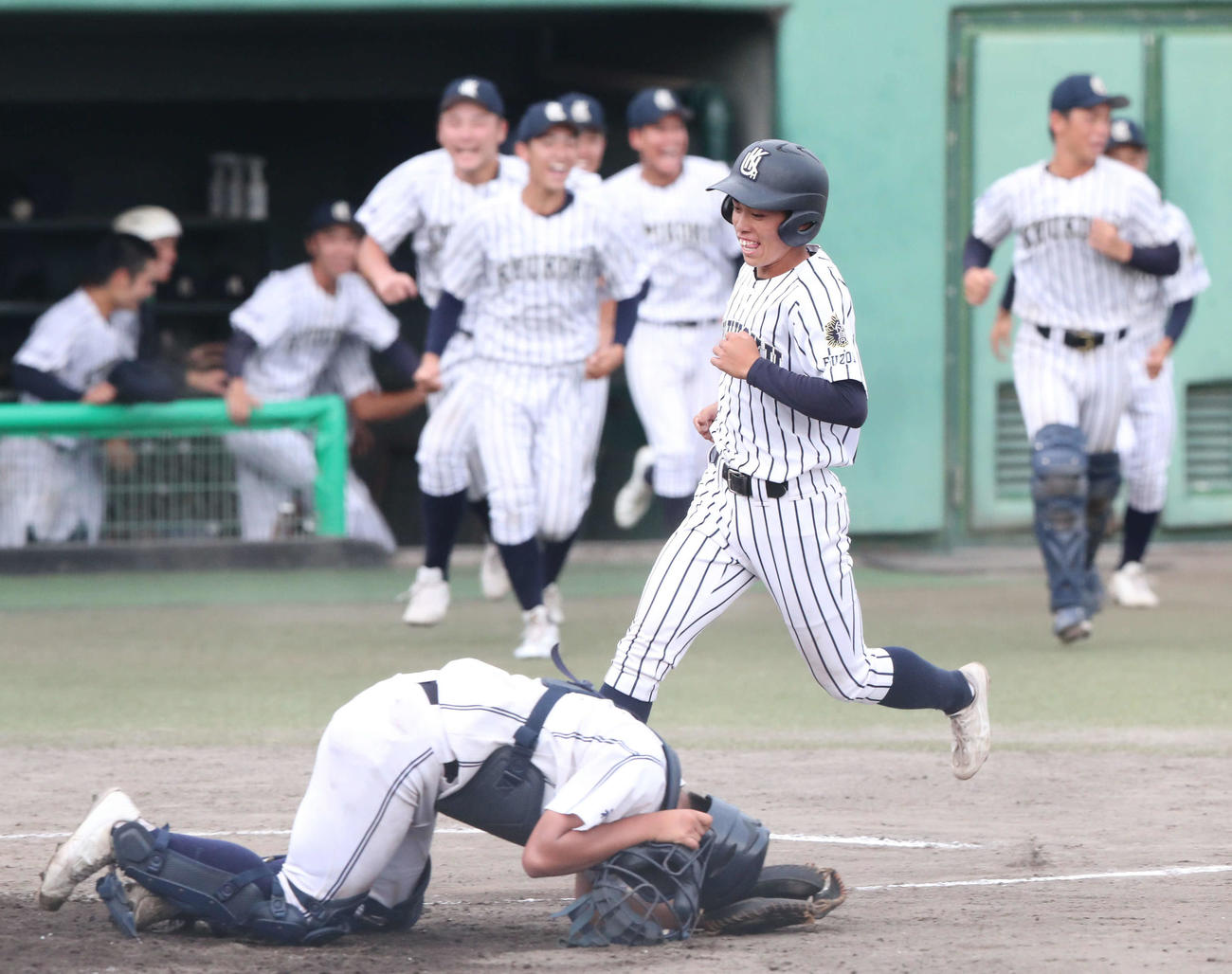 大牟田対九州国際大付　9回裏九州国際大付1死三塁、田端のサヨナラ打で生還する三塁走者の藤木（撮影・梅根麻紀）