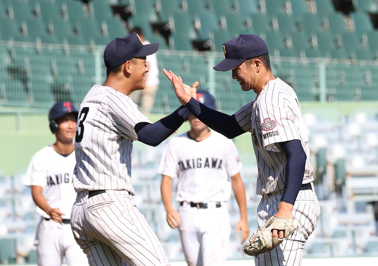 明石商対滝川二　滝川二に勝利して明石商・平松（左）とタッチを交わす横山投手（撮影・白石智彦）