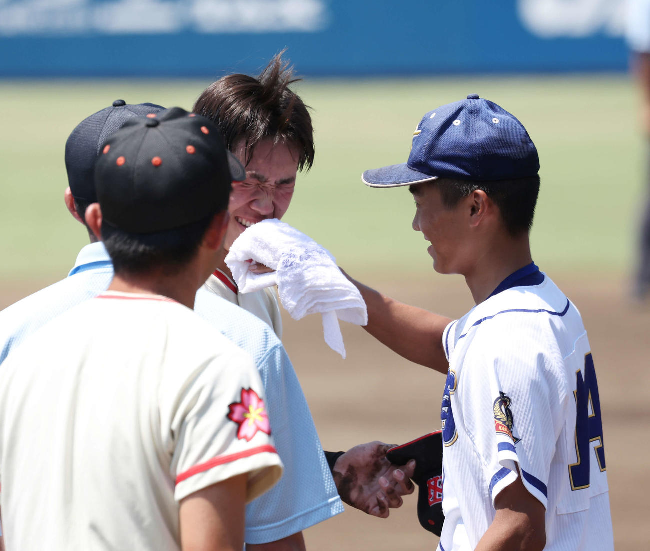 土浦日大対霞ケ浦　転倒し、汚れた顔を霞ケ浦・井上（右）に拭いてもらう土浦日大・藤本（撮影・宮地輝）