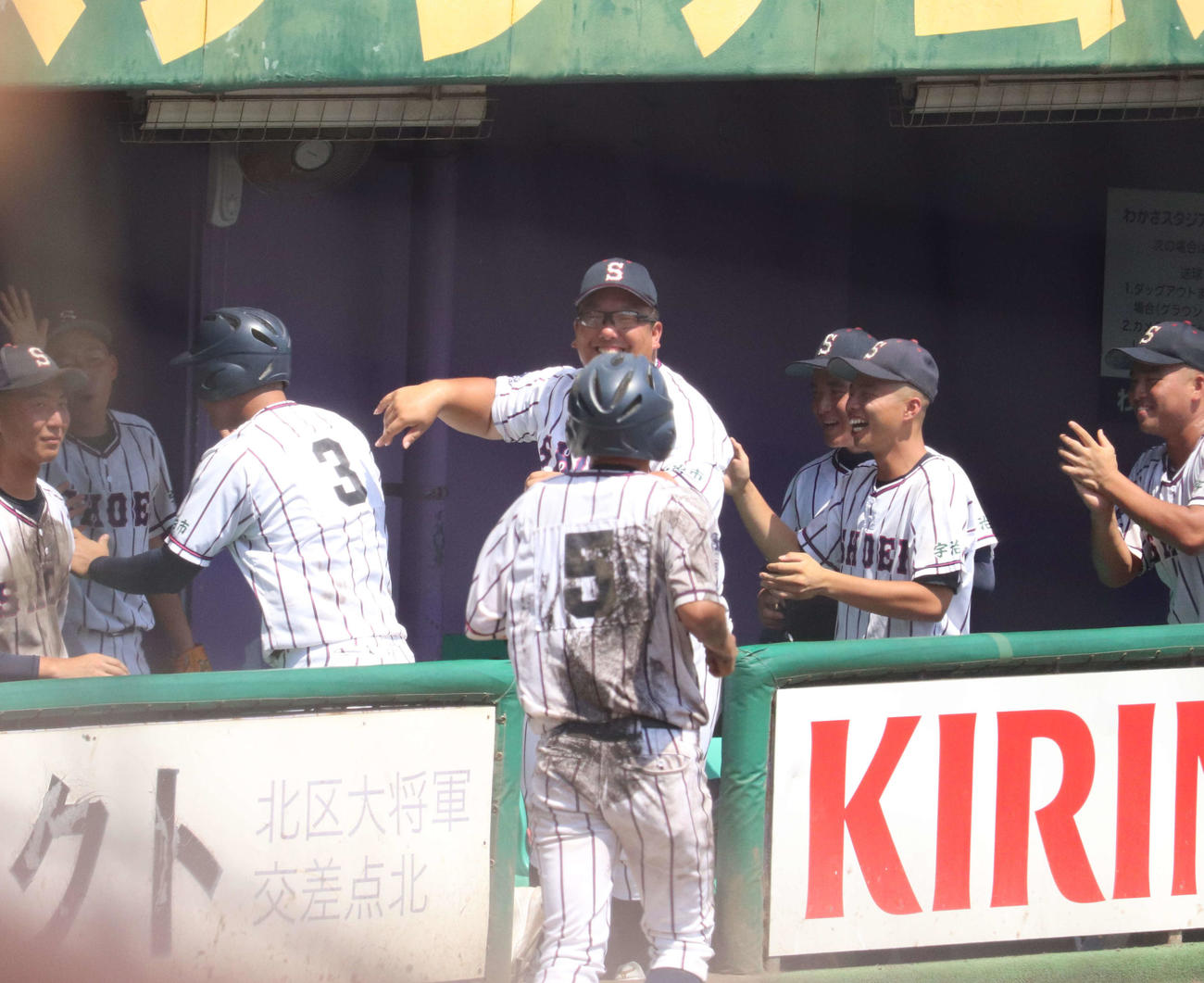 京都大会　京都翔英対立命館　7回裏一死満塁で6番藤末が右前適時打を放ち相手の失策によりホームインした小笠原蒼内野手（3年）を笑って迎える前田監督と選手ら（撮影・松野奈音）