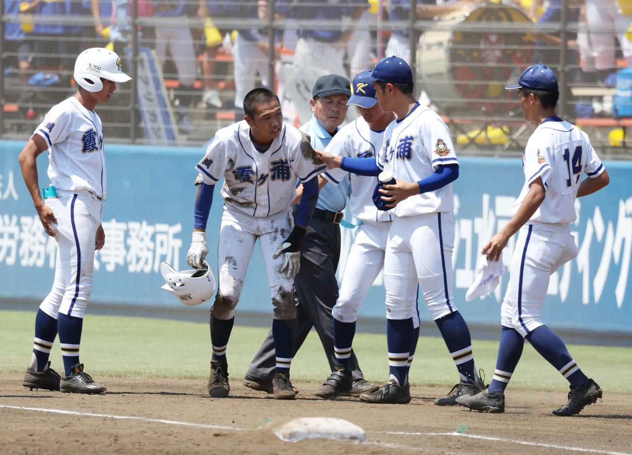 土浦日大対霞ケ浦　3回裏霞ケ浦2死二、三塁、遊ゴロ失策で出塁し転倒した木村（左から2人目）はチームメートに心配される（撮影・宮地輝）