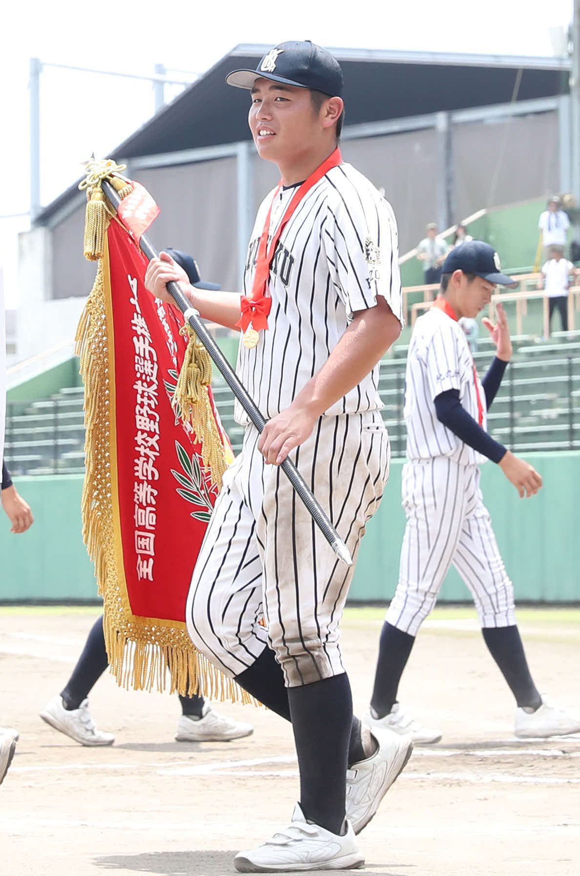 東筑対九州国際大付　優勝旗を手にダイヤモンドを回る九州国際大付・佐倉（撮影・冨田成美）