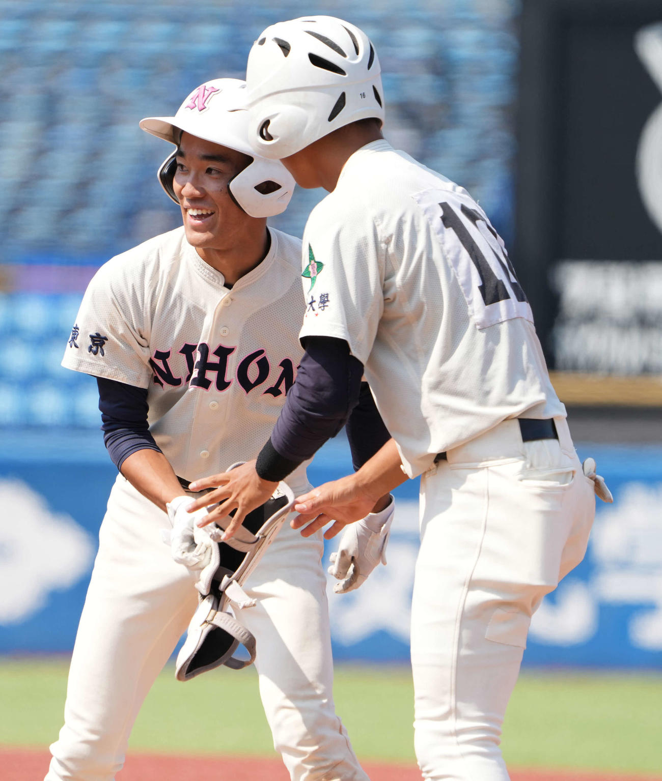 早大学院対日大鶴ヶ丘　6回裏日大鶴ヶ丘2死、梶（左）は中前打を放ち笑顔を見せる（撮影・小沢裕）