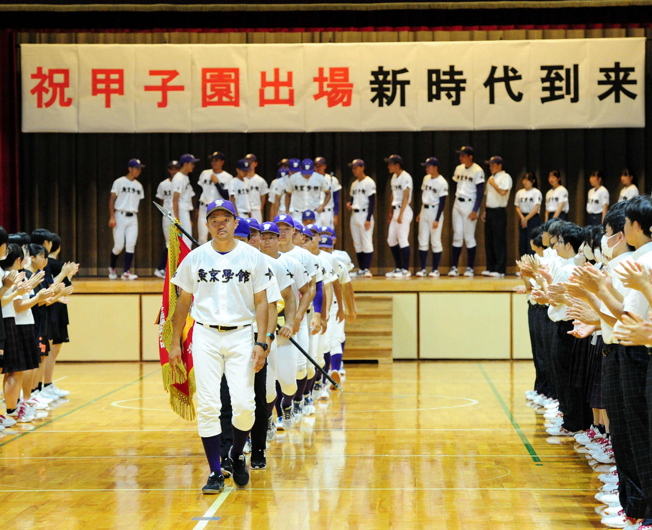 「祝甲子園出場新時代到来」の横断幕を背に、退場する東京学館新潟の旅川監督（先頭）と選手たち