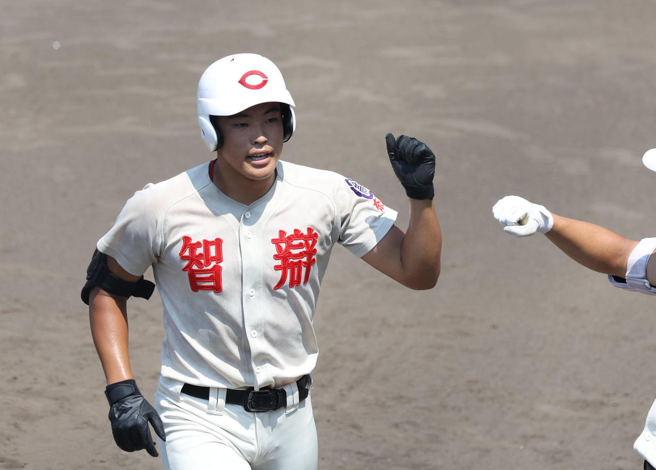 高田商対智弁学園　1回裏智弁学園無死、松本は、右越え先頭打者ホームランを放ち生還しナインとグータッチを交わす（撮影・白石智彦）