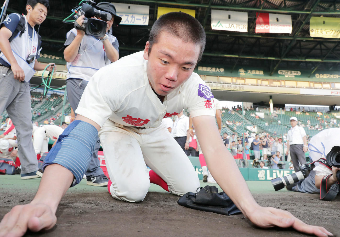 試合に敗れ、土を集める智弁学園・村上頌樹（2016年8月13日撮影）