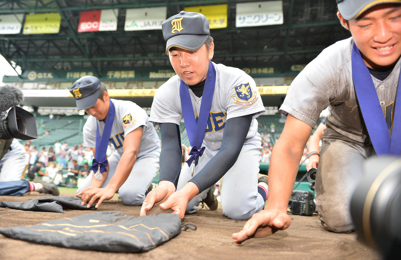 東海大相模対仙台育英　甲子園の土を集める仙台育英エース佐藤世那（中央）（2015年8月20日撮影）