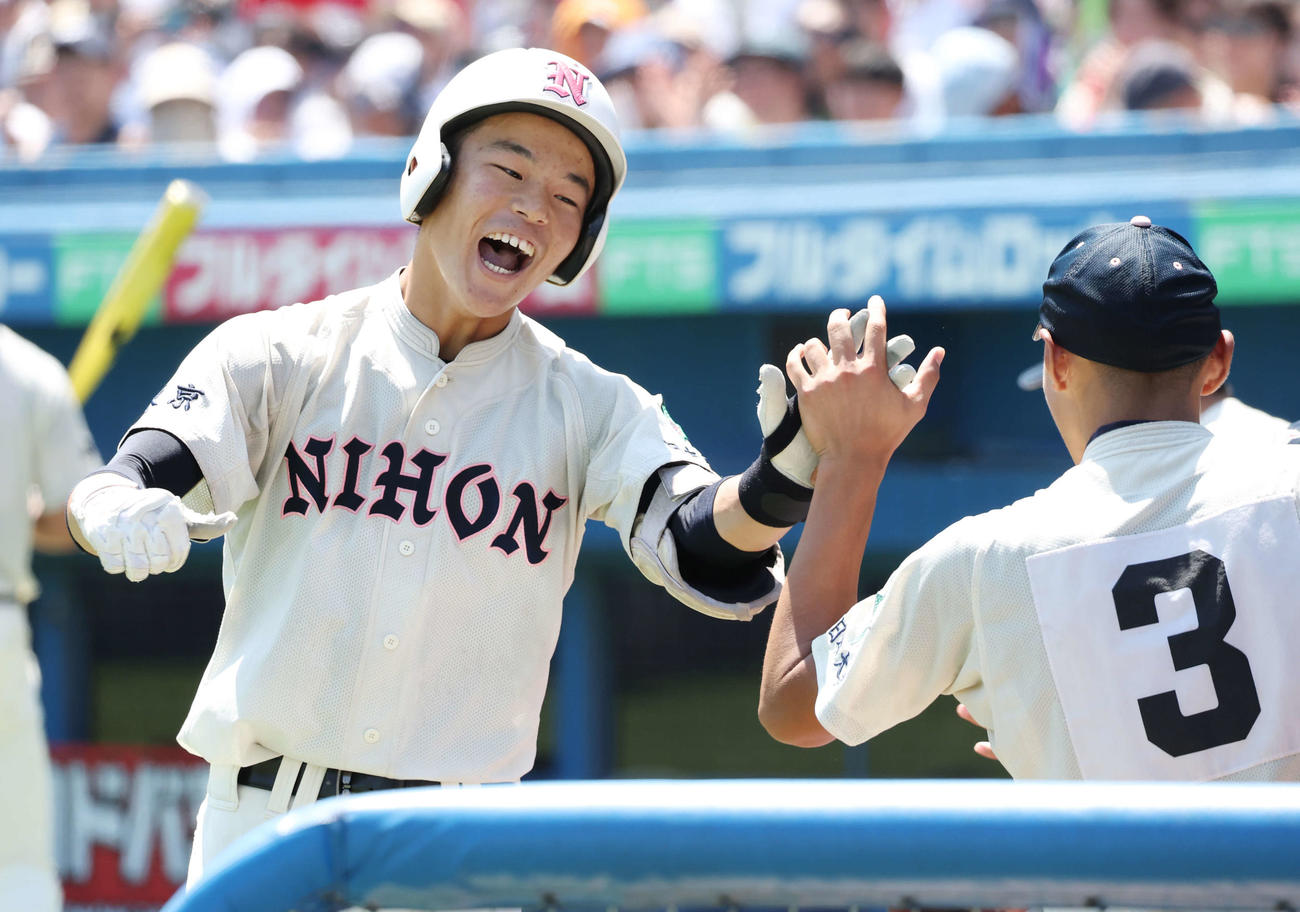 日大鶴ケ丘対日大三　4回表日大鶴ケ丘1死、左越え同点ソロ本塁打を放ち、チームメートとタッチを交わす後藤（撮影・宮地輝）